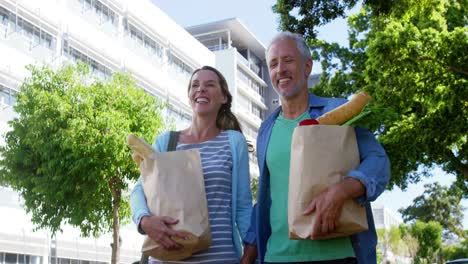 Mature-couple-is-smiling-and-walking-with-groceries