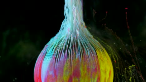 multicolored ink paint slowly flows from the ball