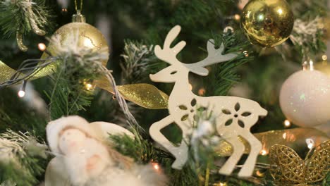 christmas tree with lights and white gold ornaments. close up