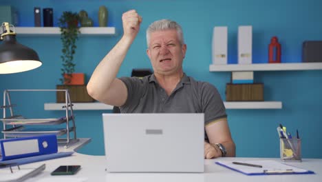 Home-Office-Arbeiter-Mann-Erlebt-Freude-Beim-Blick-In-Die-Kamera.