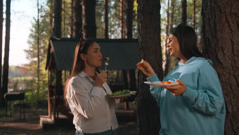 two women enjoying a picnic in the forest