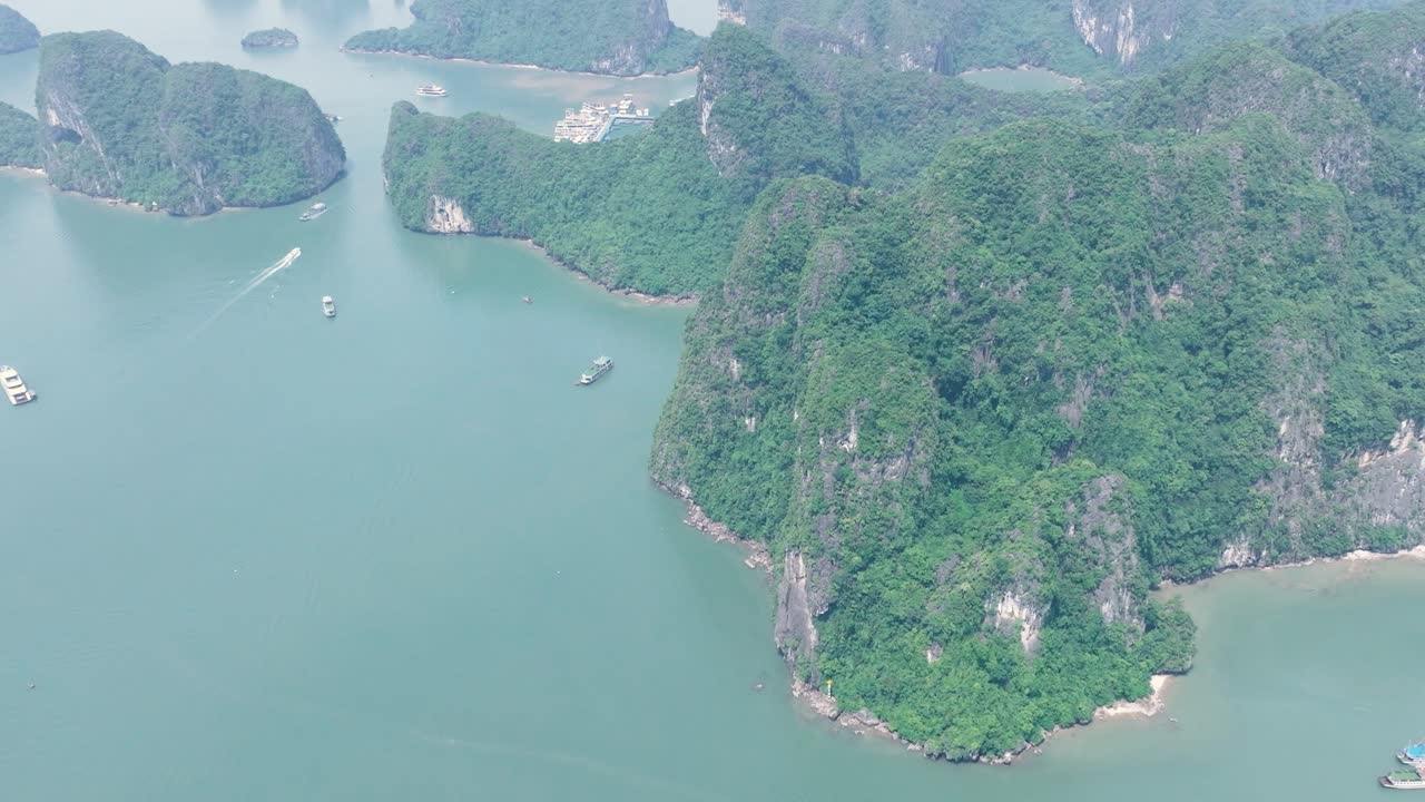 Kayakers paddling a calm river through lush cliffs in Ha Long Bay, Vietnam