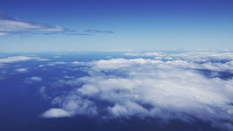 A-view-from-an-airplane-window-captures-the-majesty-of-fluffy-white-clouds-during-a-bright-and-sunny-day