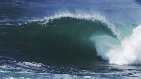 moody blue wave folds into a barrel, glowing mist trails in the backlit sea air