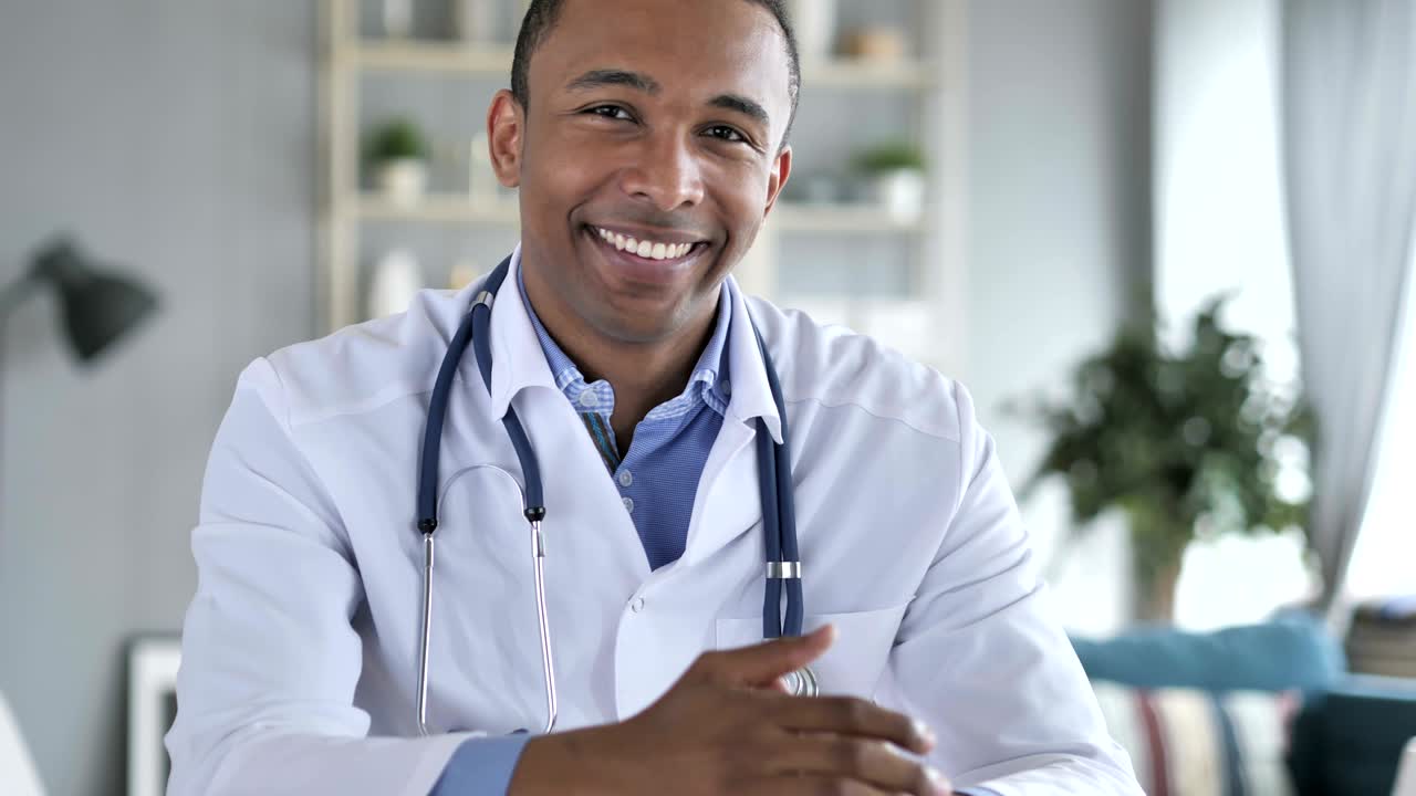 Pouce levé par un médecin afro-américain positif regardant la caméra