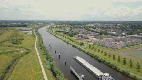 Aerial-drone-view-of-the-big-canal-and-big-container-shipping-boat-in-the-Netherlands,-Europe