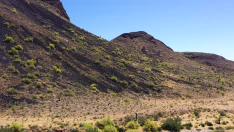 panorámica aérea desde la ladera de la montaña hasta el suelo del desierto de sonora y lavado en seco, scottsdale, arizona