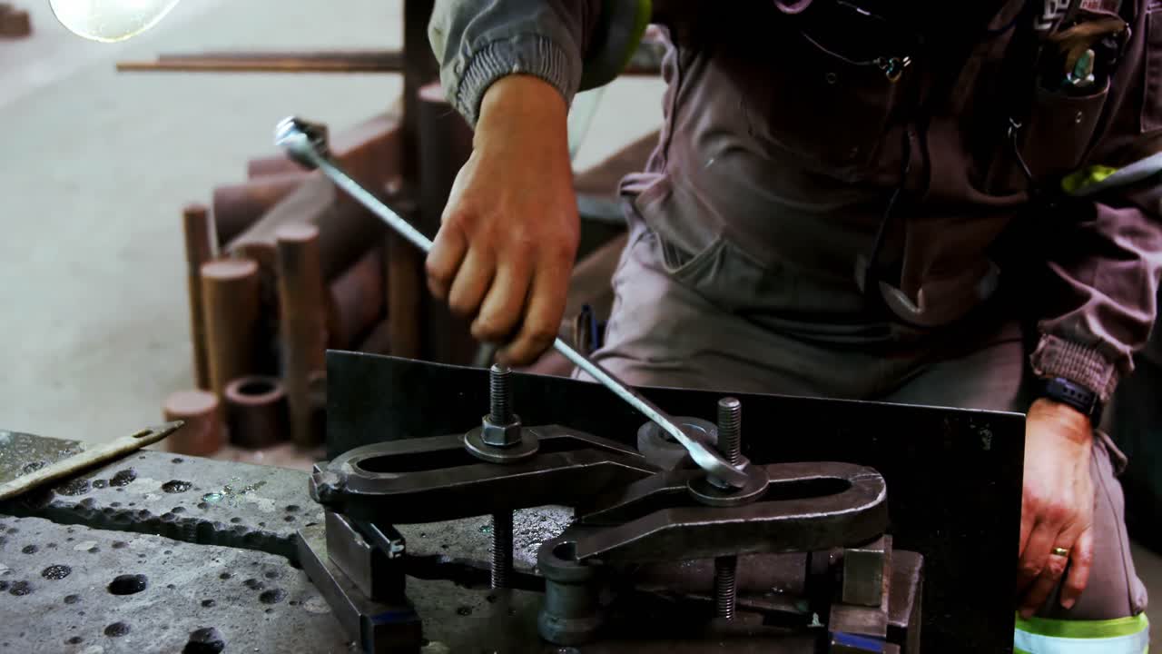 ingeniero masculino usando una herramienta de llave inglesa en el taller 4k