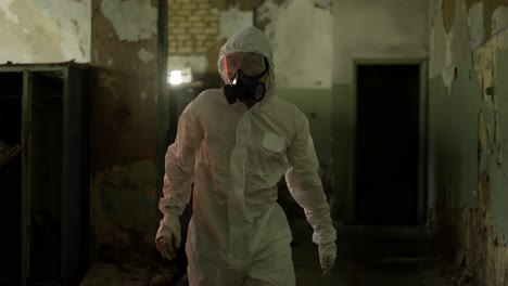 worker in protective suit inside the ruined building jumping from the destroyed locker