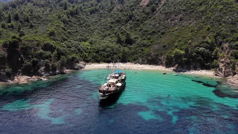 un viejo barco de madera anclado en un lugar apartado, robinson beach, sithonia, grecia