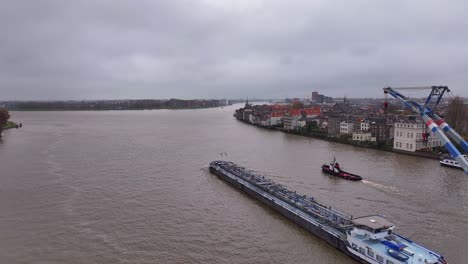 passing dordrecht city on either side, crane, tug boat and vessel sail