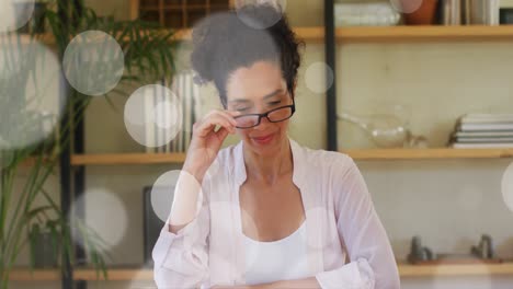 animation of white spots of light over biracial woman talking to camera