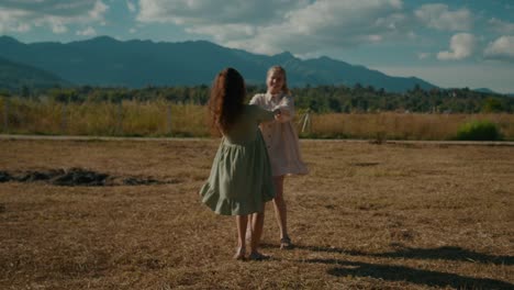two girls twirling in a field