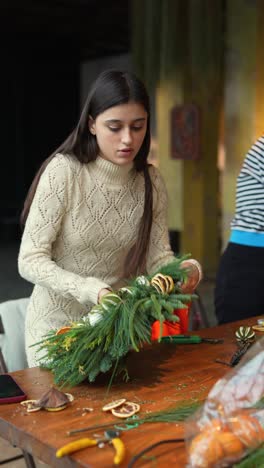 mujer creando una corona navideña festiva