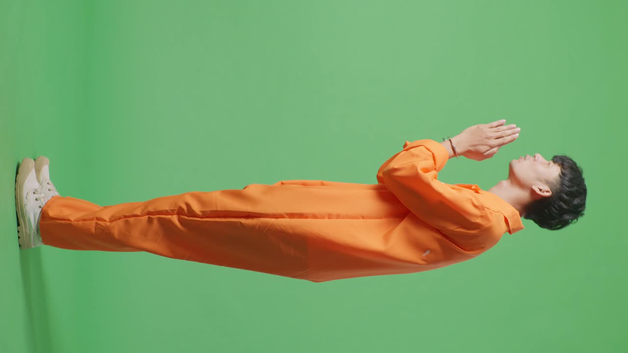 녹색 스크린에 오렌지색 스웨터를 입은 남자