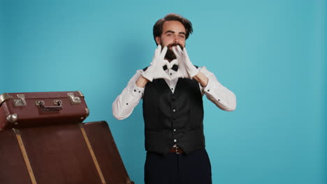 smiling bellhop does heart shape sign