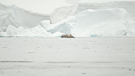 guest on board of boat cruise past a big glacier in snow storm, very dramatic