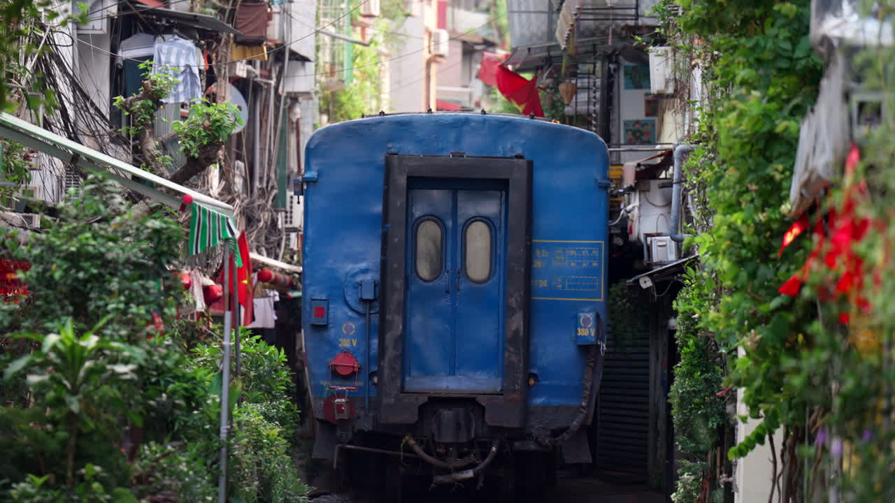 Rear view as train goes down narrow alley residential area of train street Hanoi