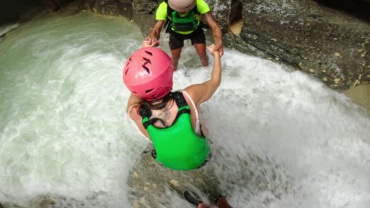 Visuale in prima persona di lavoro di squadra e fiducia nel fiume canyon Badian, Cebu, Filippine.