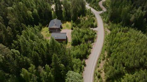 aerial tilt shot of a rv driving past detached homes on the countryside of finland