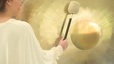 crop spiritual practitioner with hammer playing gong