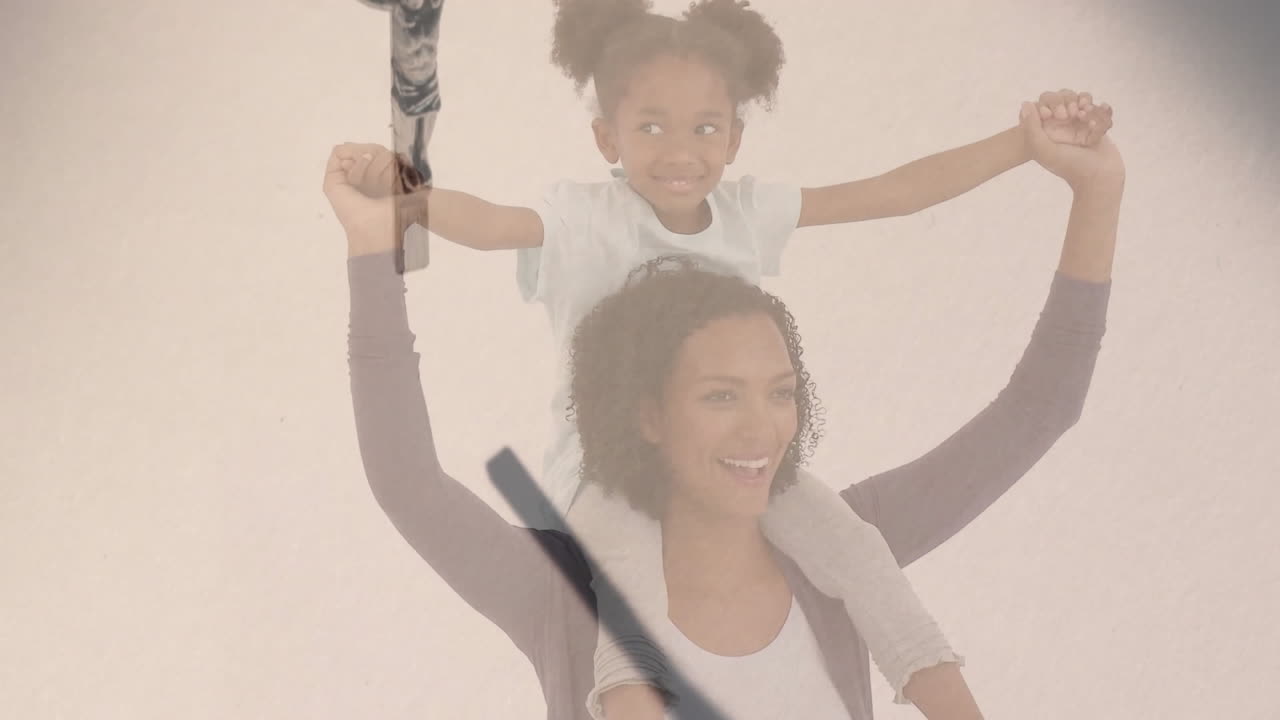 Smiling woman carrying child on shoulders with cross overlay animation