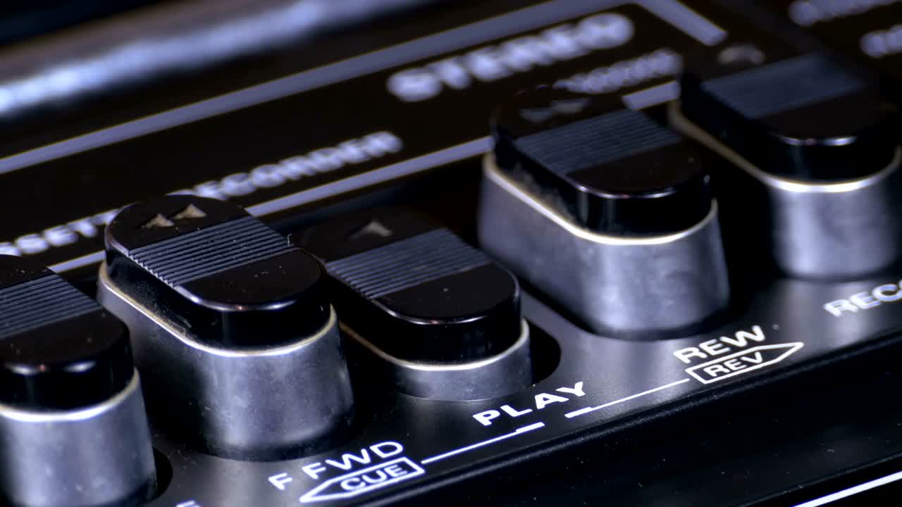 presionando el botón de un grabador de cinta, jugar, detener, grabar, ff, rew