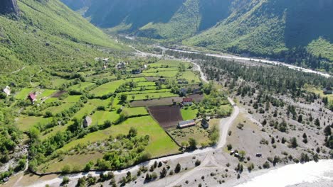 Drohnenansicht-In-Albanien-In-Den-Alpen-Vertikales-Schwenken-Des-Grünen-Tals,-Umgeben-Von-Bergen-Im-Theth