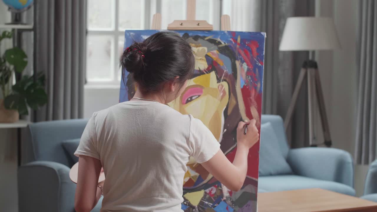 Hind View Of Asian Artist Girl Holding Paintbrush Mixed Colour And Thinking Before Painting A Girl'S On The Canvas