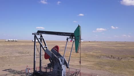 Oil-industry-pumpjack-juxtaposed-against-commercial-transport-trucks