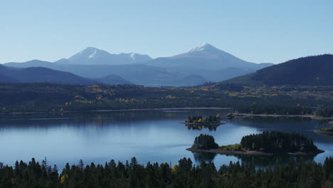 Early-fall-colors-Lake-Dillon-Colorado-aerial-cinematic-drone-morning-view-Frisco-Breckenridge-Silverthorne-Ten-Mile-Range-peaceful-calm-reflective-water-yellow-Aspen-trees-forward-slowly-movement