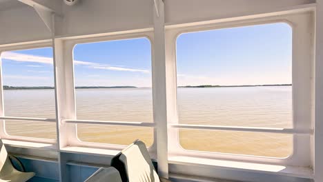una vista tranquila del río desde la ventana de un barco.