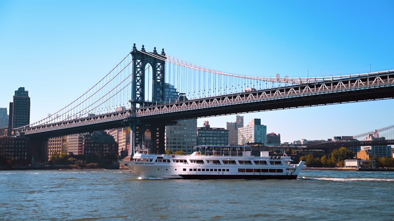 New York, USA, 9 August 2025: Cruise ship passing under Manhattan Bridge in New York City. A white cruise ship sails under the Manhattan Bridge with the skyline of New York City in the background