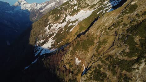 aerial view of drone flying over ridge forest near alpine mountain peaks in spring. patches of snow. video footage with drone stock video