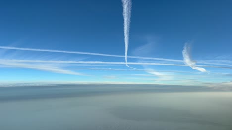 Unique-pilot-point-of-view-of-a-busy-sky-full-of-jet-wakes-over-a-hazy-sky-in-a-deep-blue-sky-early-in-the-morning