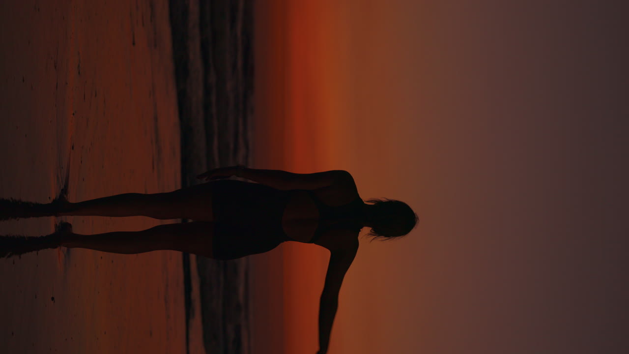Mujer practicando yoga en la playa al atardecer