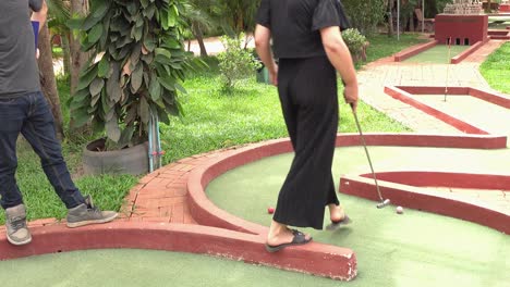 Amigos-Divirtiéndose-Bajo-El-Sol-En-El-Campo-De-Minigolf