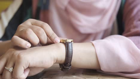 woman checking time on wristwatch