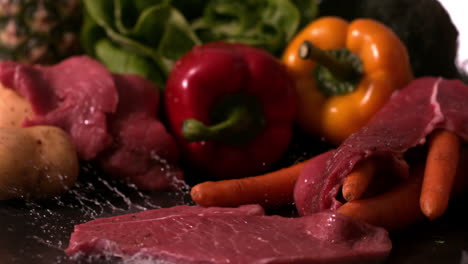 bife de res cayendo delante de la selección de verduras