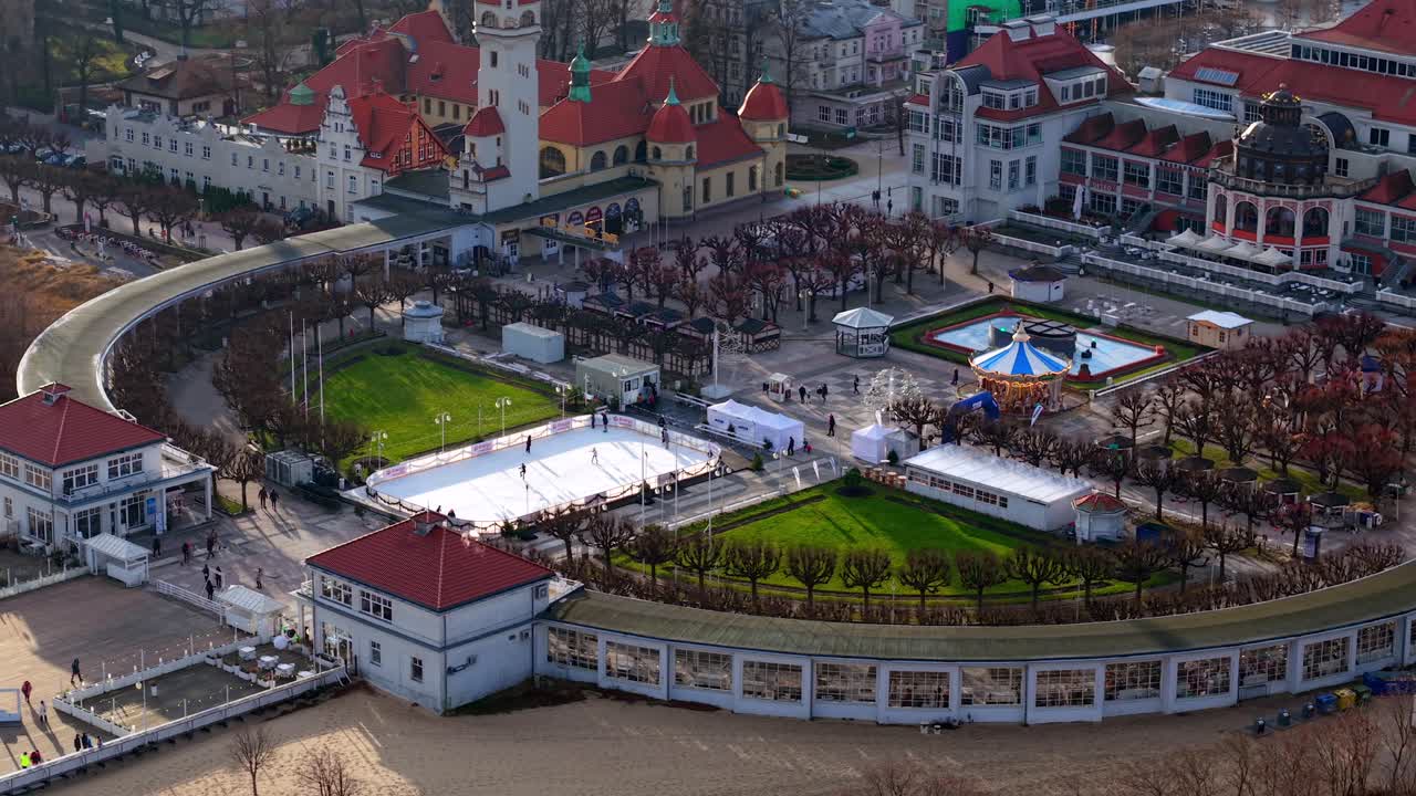 Aerial drone overview of Zdrojowy Square, Sopot Lighthouse, ice rink, and Spa House in winter