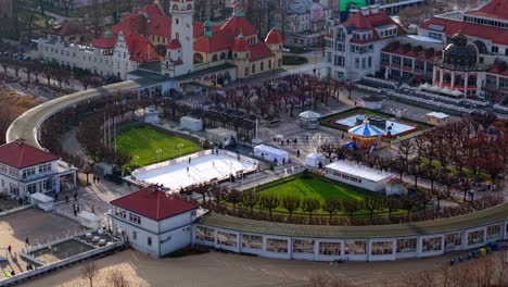 aerial drone overview of zdrojowy square, sopot lighthouse, ice rink, and spa house in winter