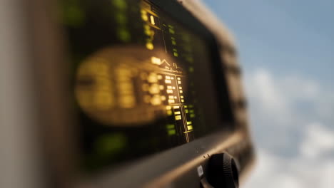 close-up of an electronic display or control panel with glowing elements against a sky background