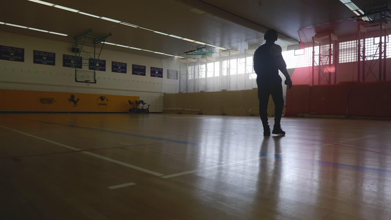 hombre caminando a la vista y mirando a la corte - hombre negro musculoso atlético fuerte parado en la cancha de baloncesto mirando alrededor en 4k