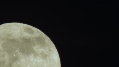 Extreme-Close-up-of-Full-Moon-Rising-from-Lower-Left-Corner-of-Frame