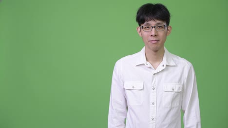 손을 잡으면서 미소 짓는 젊은 아시아 사업가