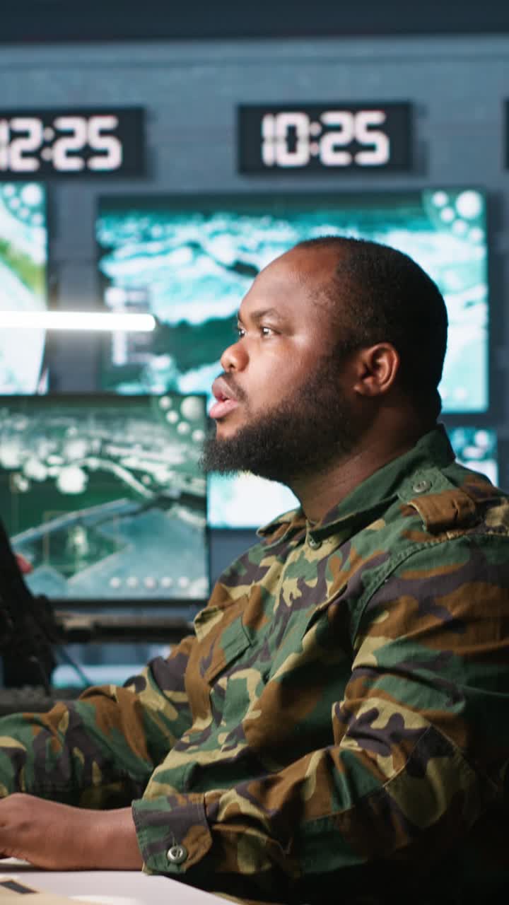 Vertical video Intelligence corps agent checking screens, discussing with colleague