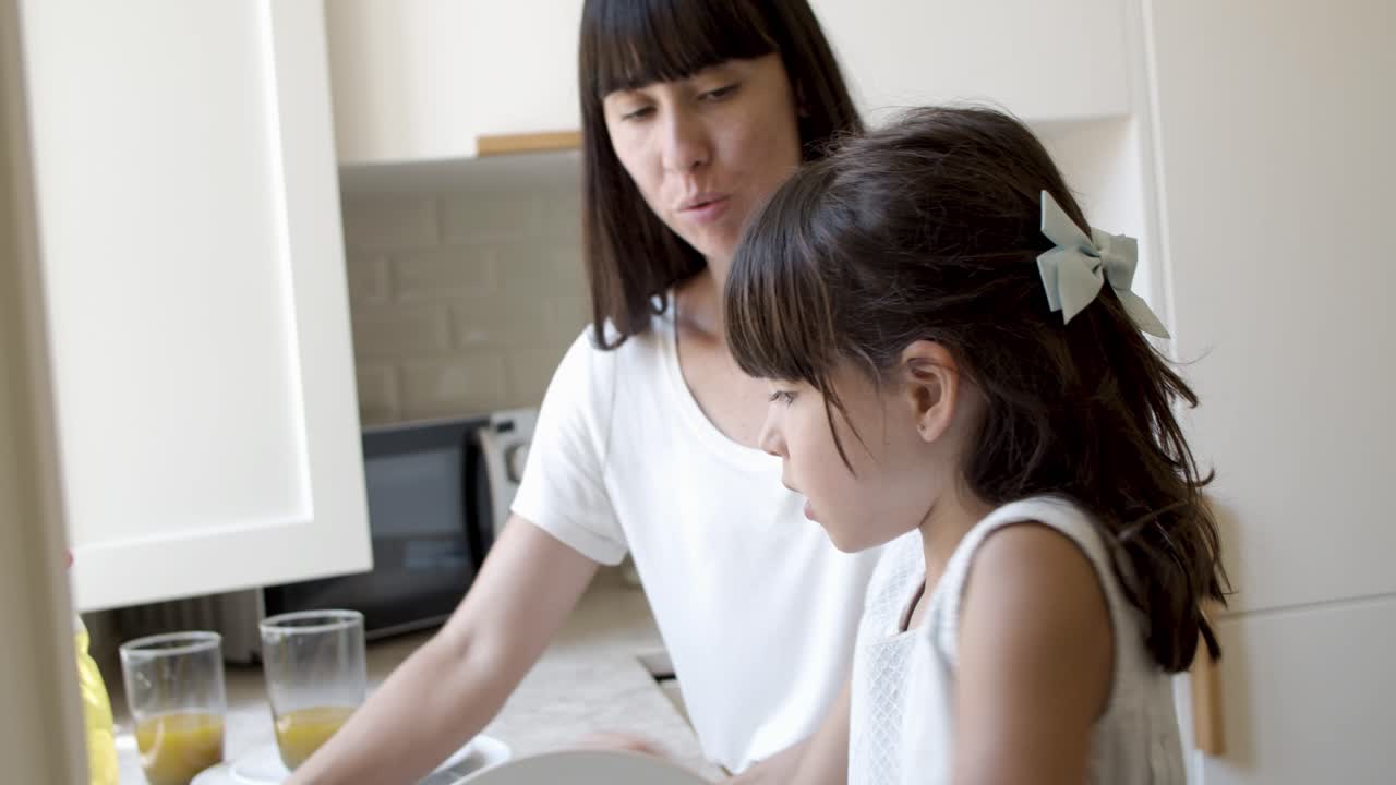 엄마 와 딸 이 아침 식사 후 함께 접시 를  ⁇ 고 있다