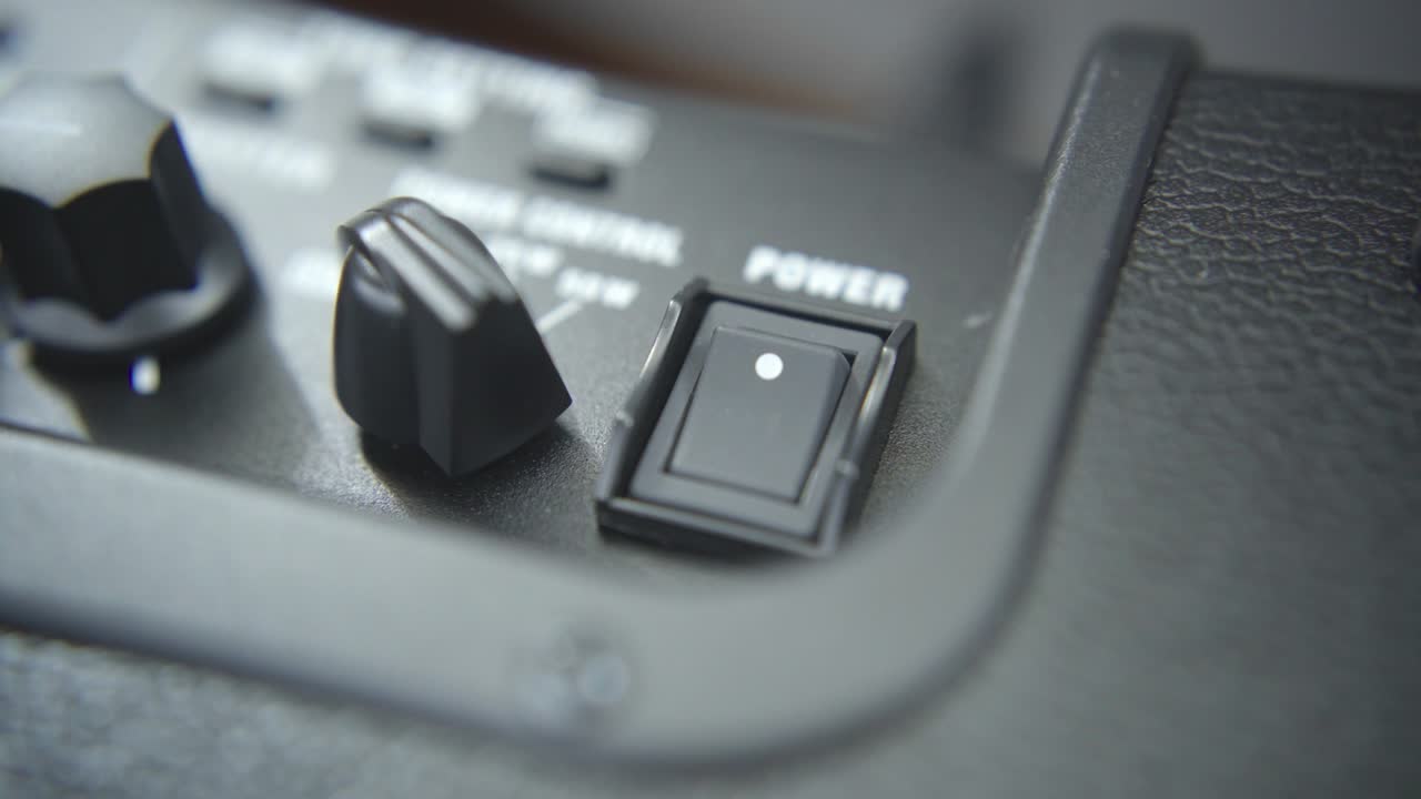 presionando un interruptor de energía de un amplificador de guitarra