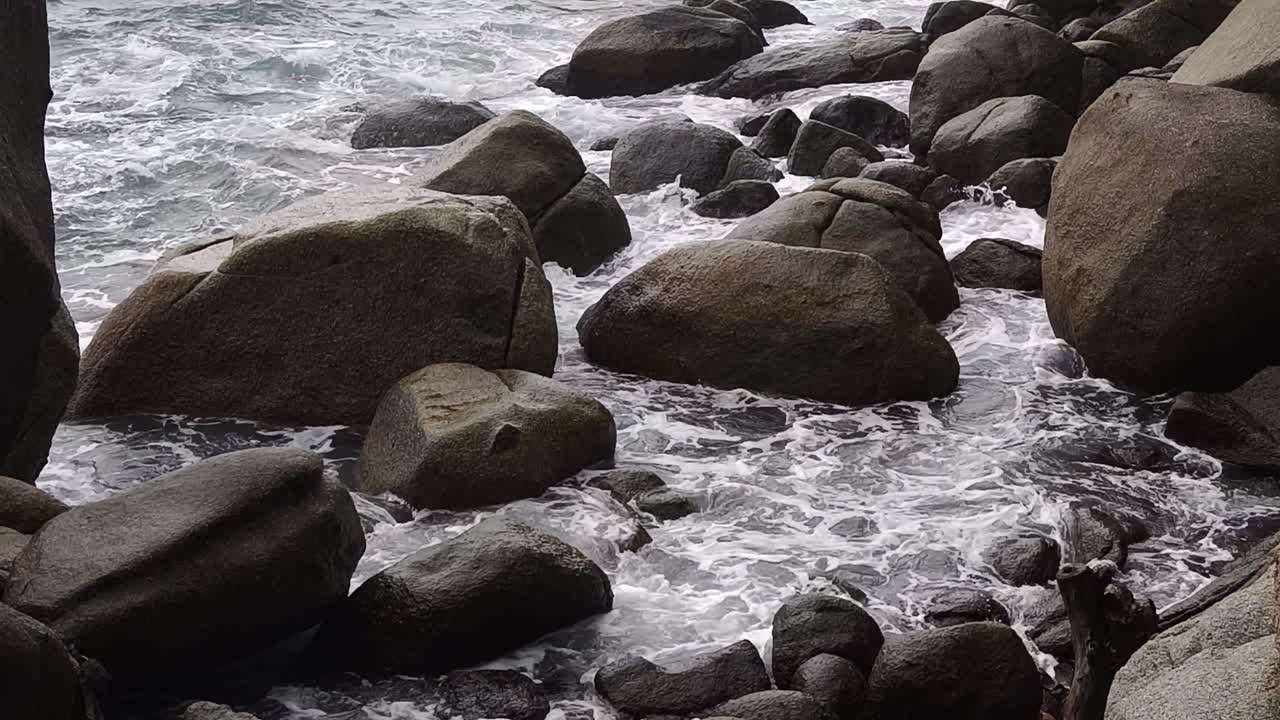 바다의 파도가 바위가 있는 해변에 부히고