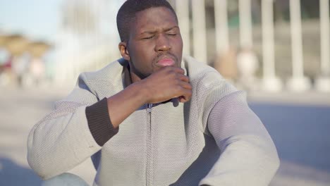 man sitting on stairs in park, looking around, thinking